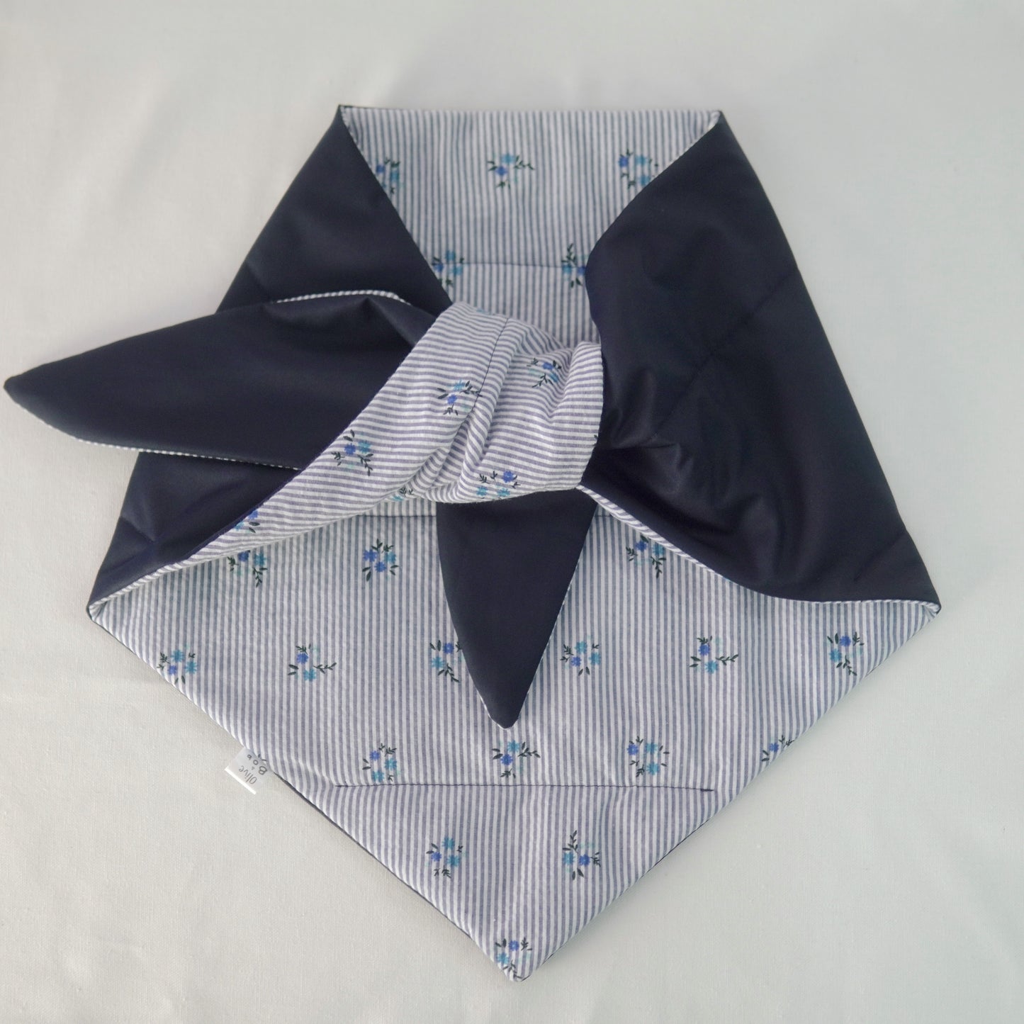 Reversible quilted shawl with a dark floral cotton print and water-resistant black lining, perfect for elegant layering and cool weather style.