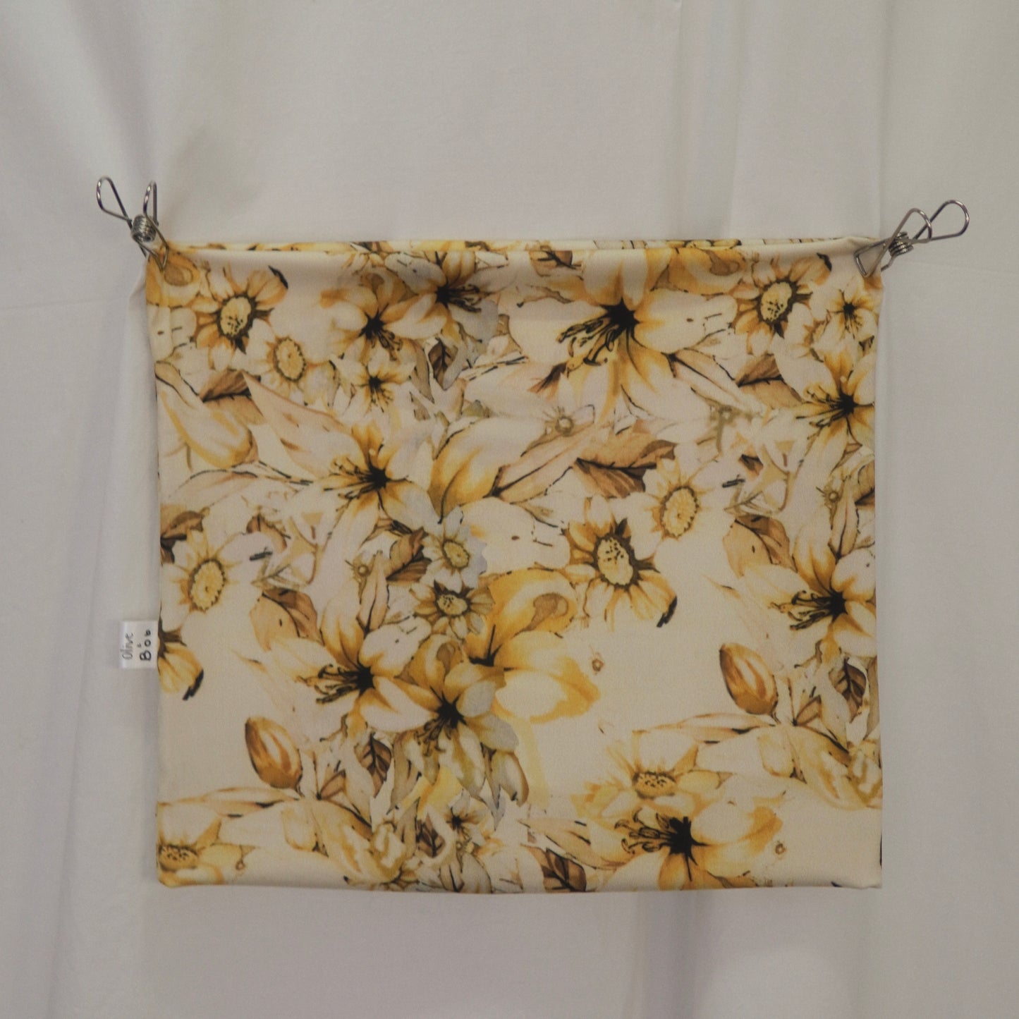 Yellow floral fabric tube top displayed flat against a white background, secured with clips at the top corners. The fabric features a detailed pattern of golden-yellow flowers with brown and cream accents, creating a vibrant and elegant design