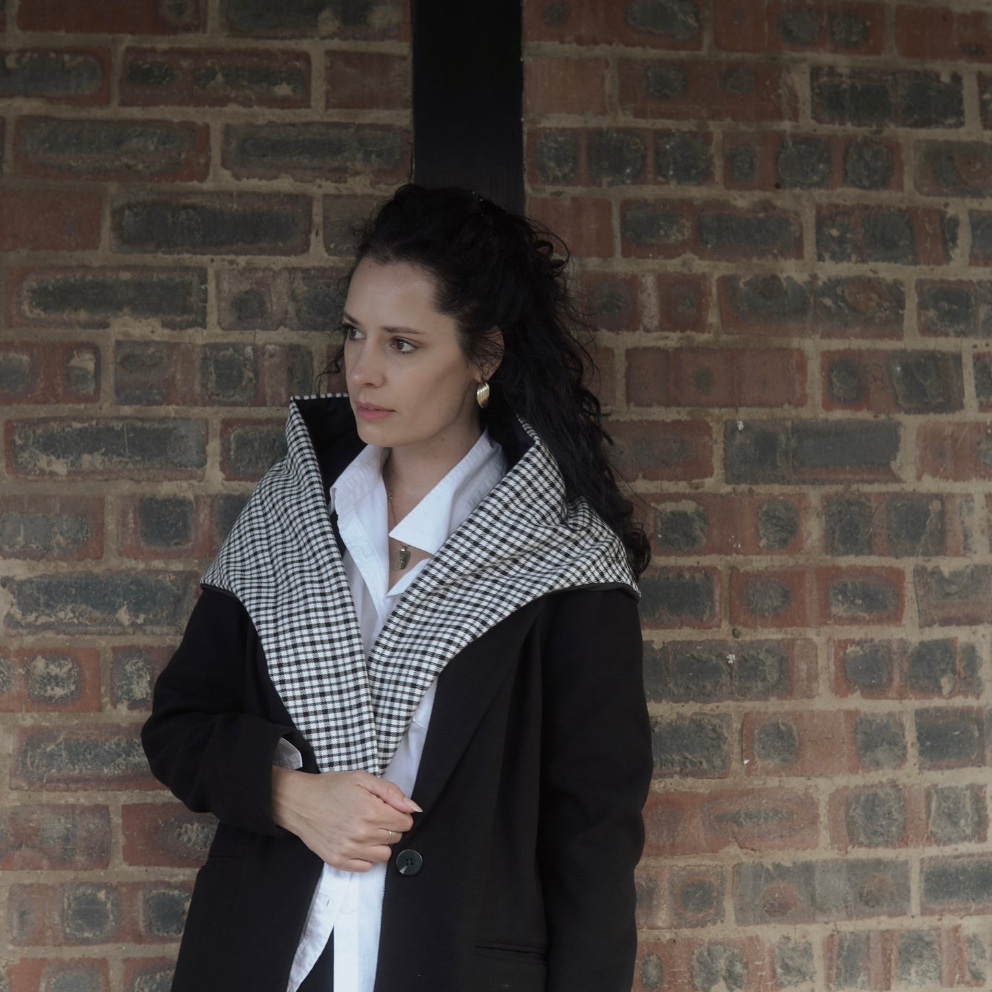 Reversible black and white quilted shawl with water-resistant outer and patterned polyester lining, ideal for stylish, lightweight layering in all seasons.