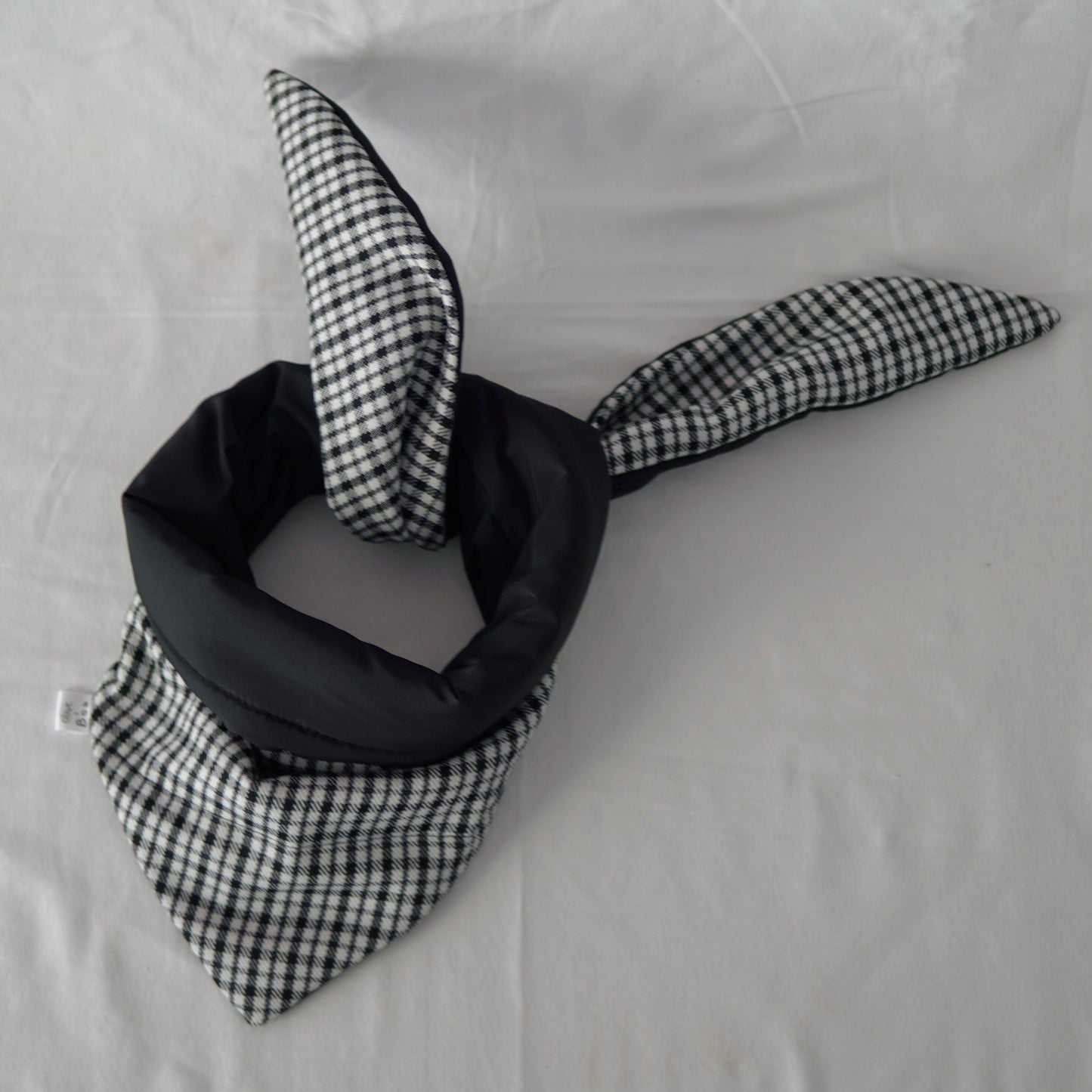 Reversible black and white quilted shawl with water-resistant outer and patterned polyester lining, ideal for stylish, lightweight layering in all seasons.