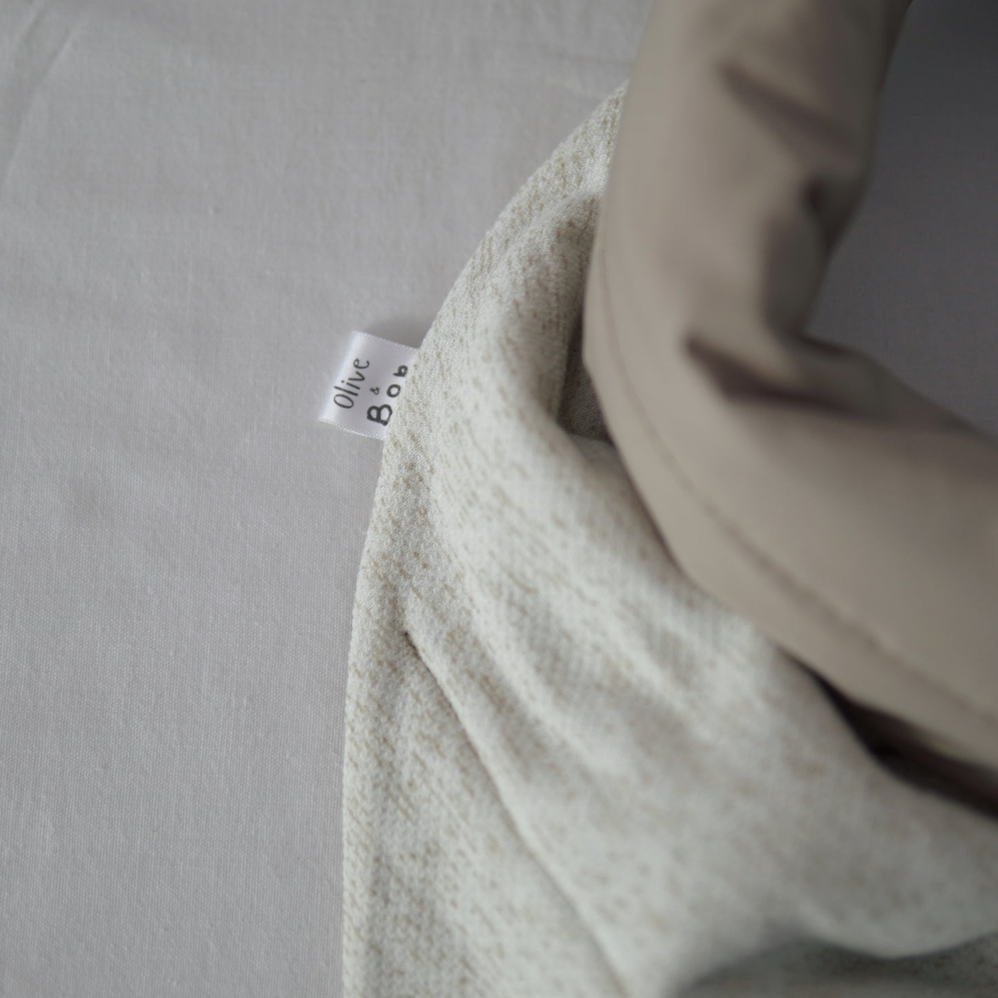 Reversible quilted shawl in soft sand-toned cotton and oat-hued linen, designed for effortless layering with a natural, textured finish.