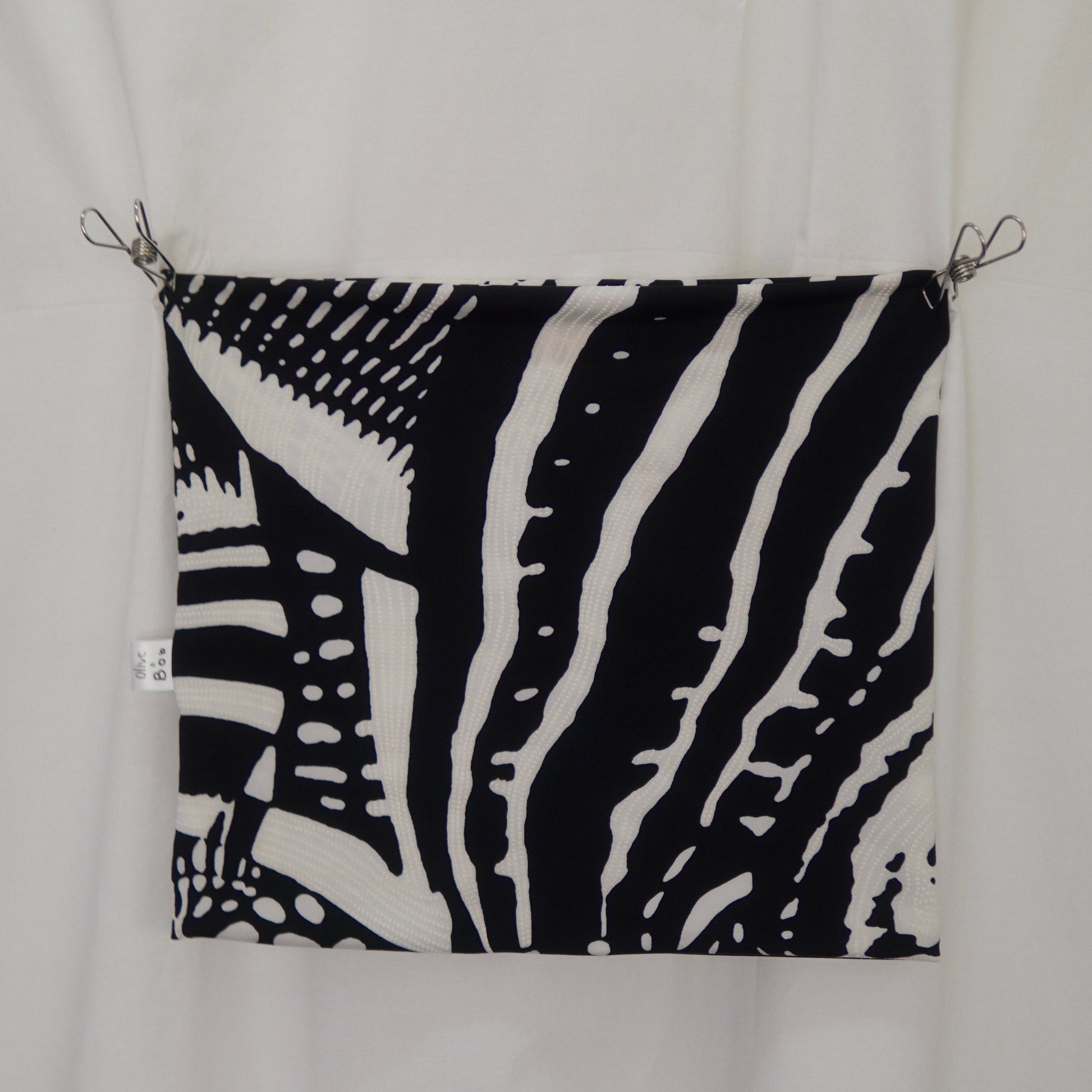 A black-and-white tube top featuring a striking abstract design with bold lines and dotted patterns, resembling a modern art motif. The fabric is displayed flat, pinned against a white backdrop, highlighting its unique print and texture.