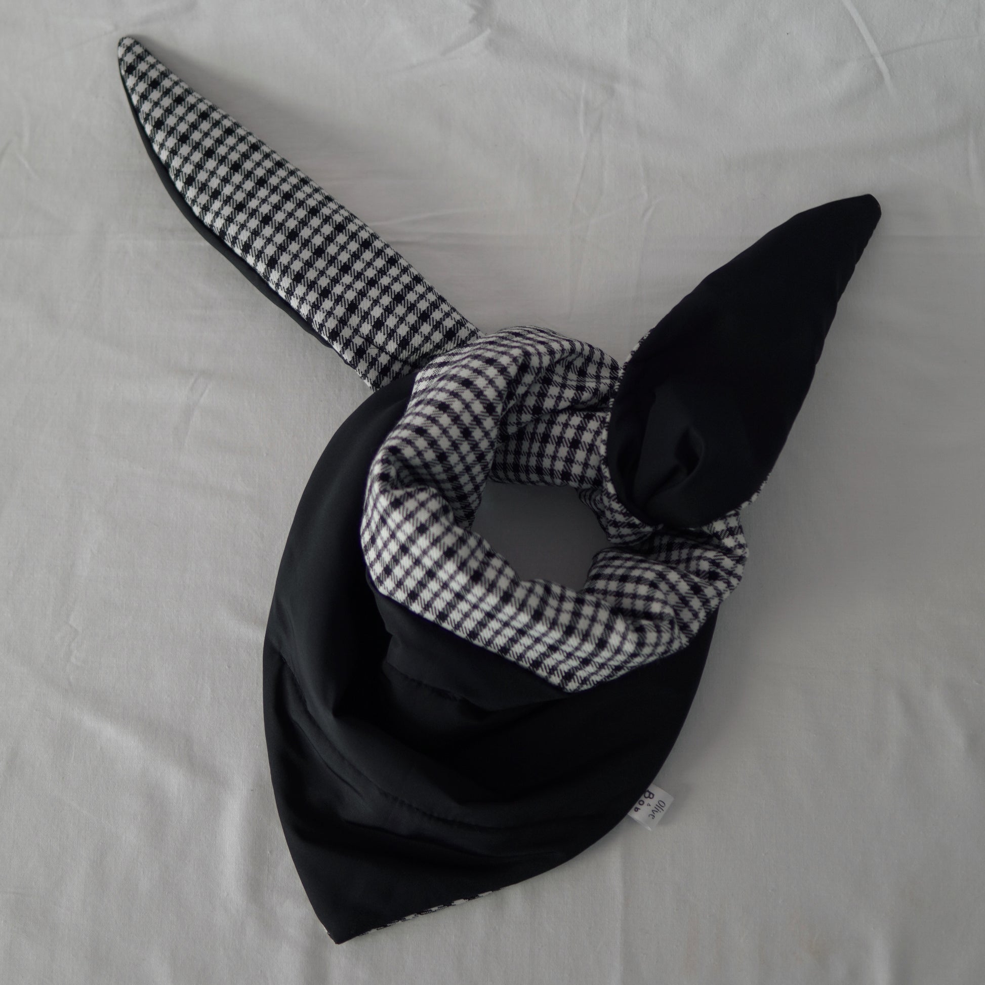 Reversible black and white quilted shawl with water-resistant outer and patterned polyester lining, ideal for stylish, lightweight layering in all seasons.